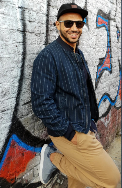 Abdel standing beside a colourful wall